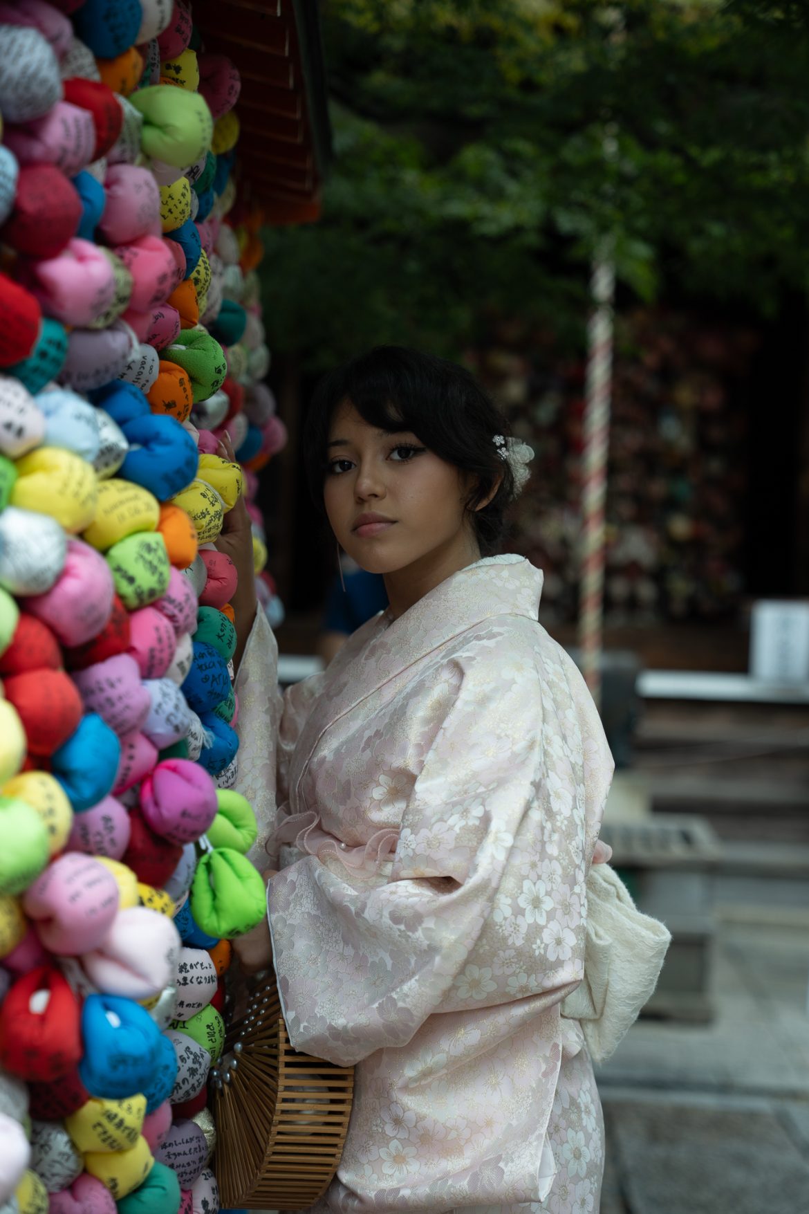 Arianna beside colorful charms at a Kyoto shrine