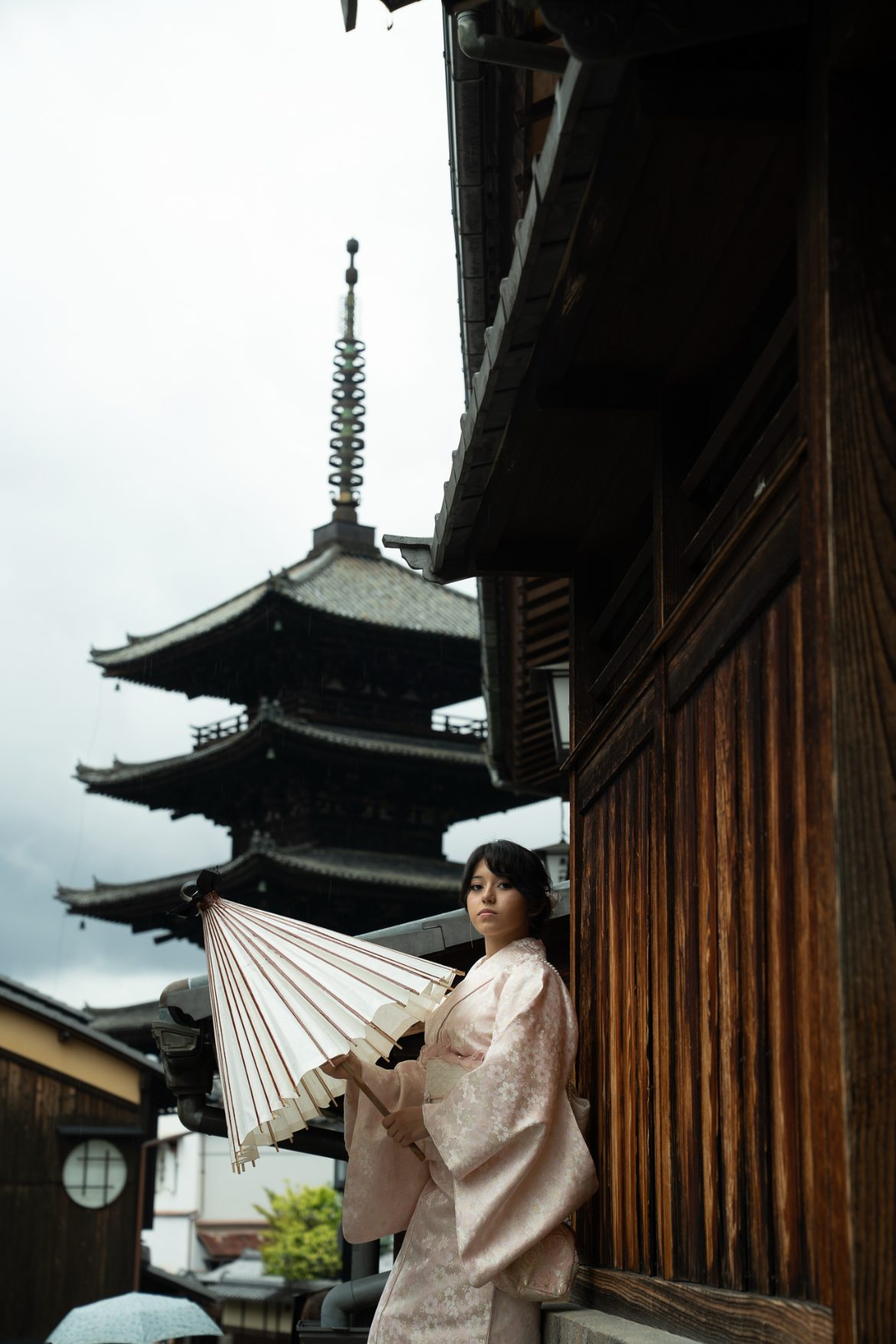 Arianna with a paper parasol beside a pagoda in Kyoto